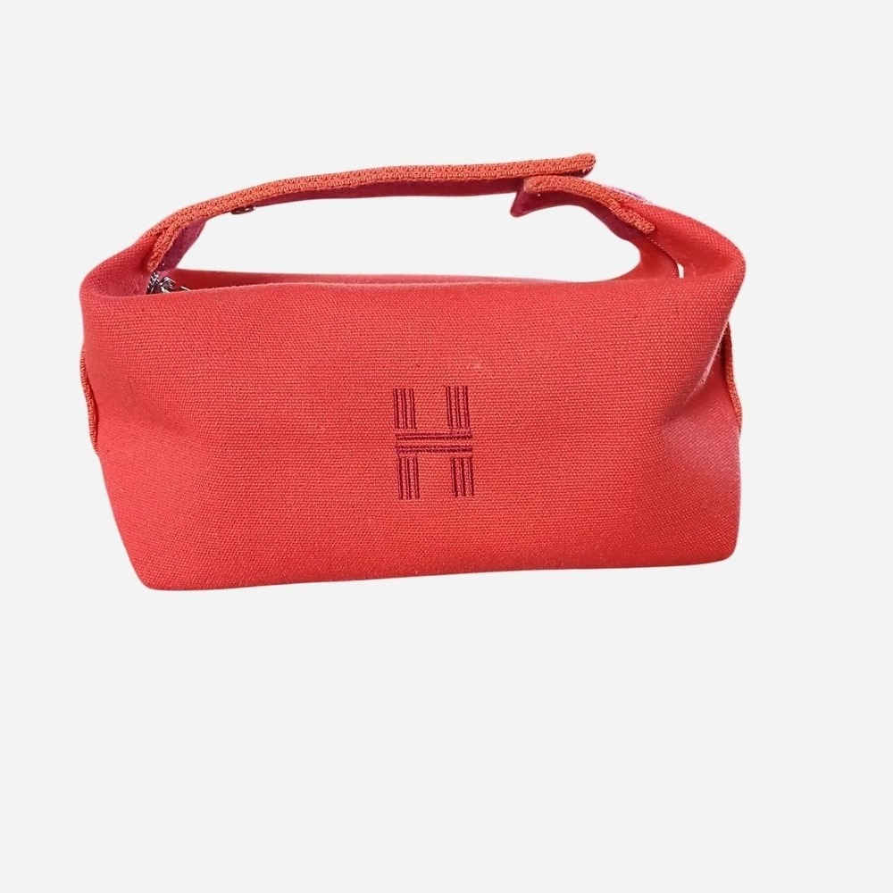 Orange canvas cosmetic bag with embroidered "H"